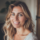 Femme souriante aux cheveux blonds et yeux bleus.